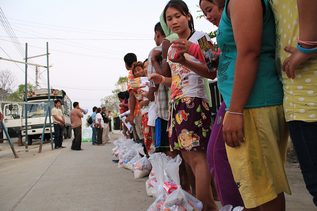 Migrant workers from Laos and Myanmar line up to collect donations after the 2011 floods. Photo by ILO in Asia and the Pacific, Flickr, taken 25 November 2011. Licensed under CC BY-NC-ND 2.0